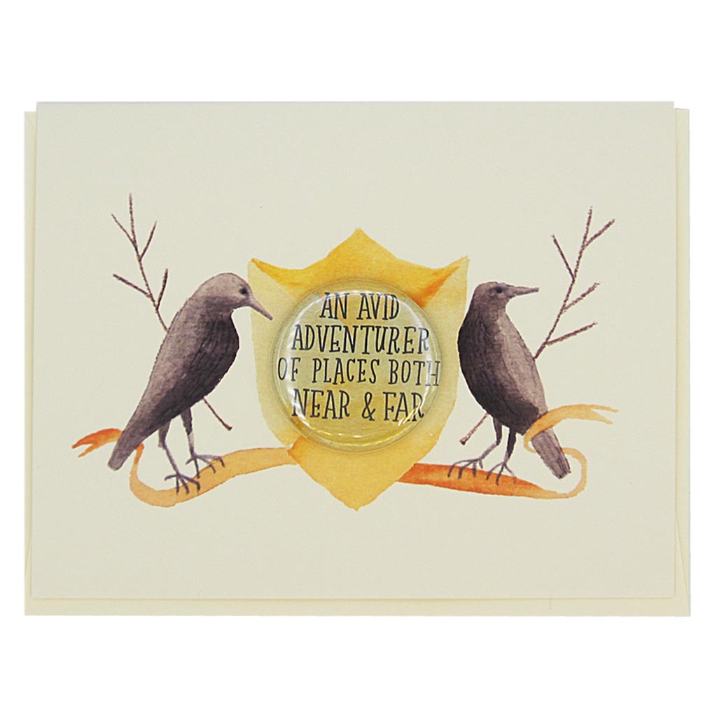This lovely card features a watercolour painting of two crows on either side of a crest. There is a 1½” button in the middle of the crest which reads ‘an avid adventurer of places both near & far’. The button can be taken off and worn by the recipient. Card measures 4¼” x 5½”, comes with a cream envelope & is blank inside. Designed by The Regional Assembly of Text.