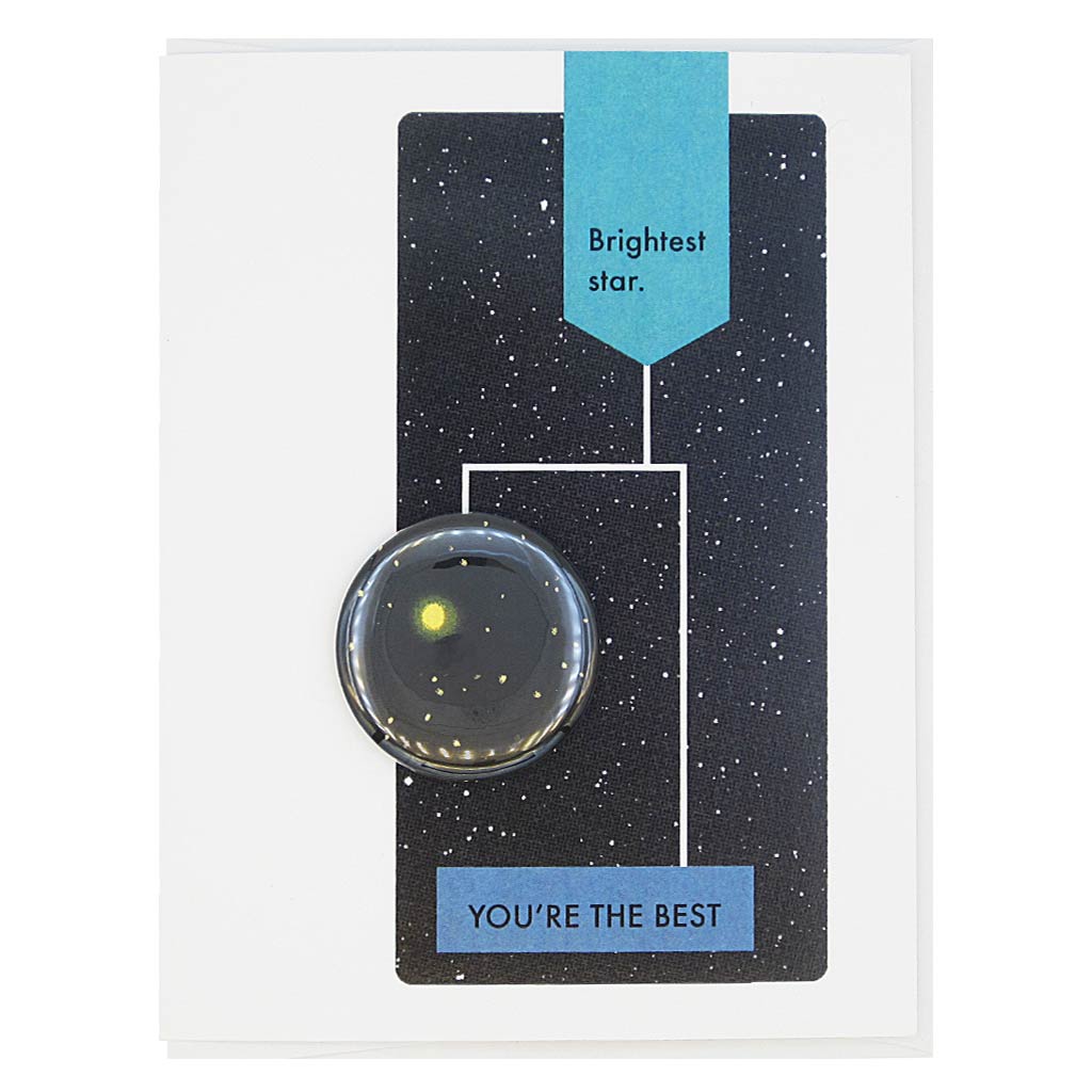 This greeting card is designed to look like a page from a vintage science textbook with a black background of a starry sky. The text reads, ‘Brightest Star’ with an arrow to the text ‘You’re the Best’ with an arrow to a 1½” button Stars in the Night Sky that can be taken off and worn by the recipient. Card measures 4¼” x 5½”, comes with a white envelope & is blank inside. Designed by The Regional Assembly of Text.