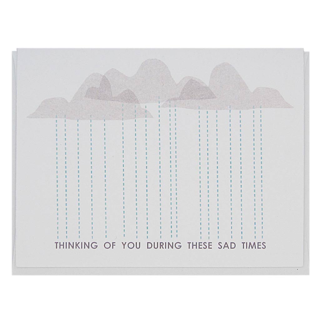 This greeting card features some grey clouds with rain falling down into text along the bottom that reads… ‘Thinking of you during these sad times’. Measures 4¼” x 5½”, comes with a white envelope & is blank inside. Designed by The Regional Assembly of Text.