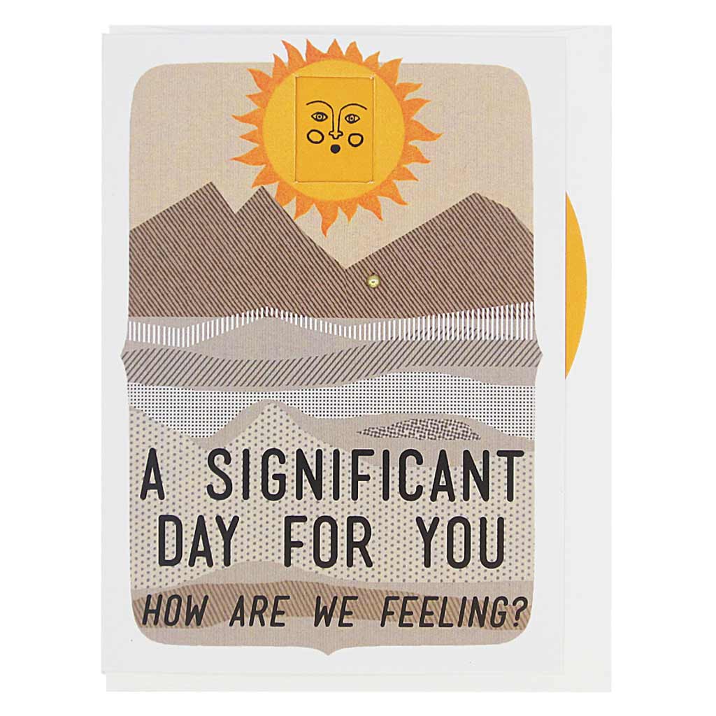 This greeting card features a landscape with a sun on the horizon. The sun has a face and you can turn a wheel to find an appropriate facial expression for this occasion. The card reads, ‘A Significant Day for You… how are we feeling?’ There are 8 faces to choose from: sad, mad, worried, smiling, winking, frowning etc. Card measures 4¼” x 5½”, comes with a white envelope & is blank inside. Designed by The Regional Assembly of Text.